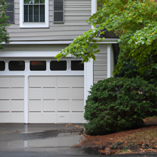 Concord residential two-car garage with closed modern raised-panel steel door on a wet morning street.
